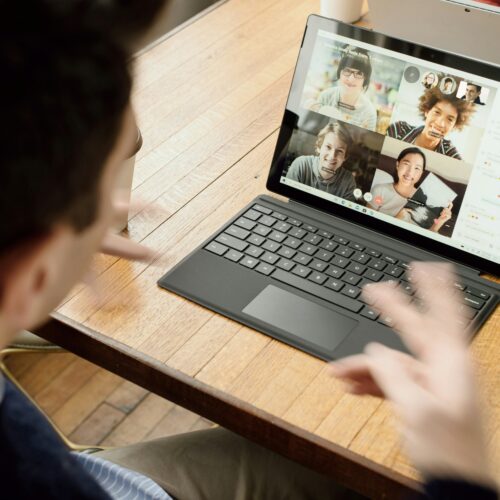 Person attending a video conference on a laptop with four participants visible on screen