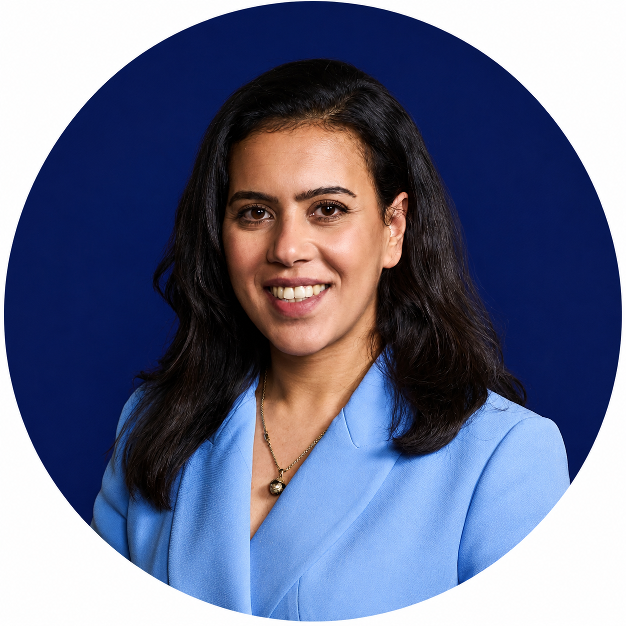 Smiling woman with long dark hair wearing a light-blue blazer and pendant necklace against a dark-blue circular background