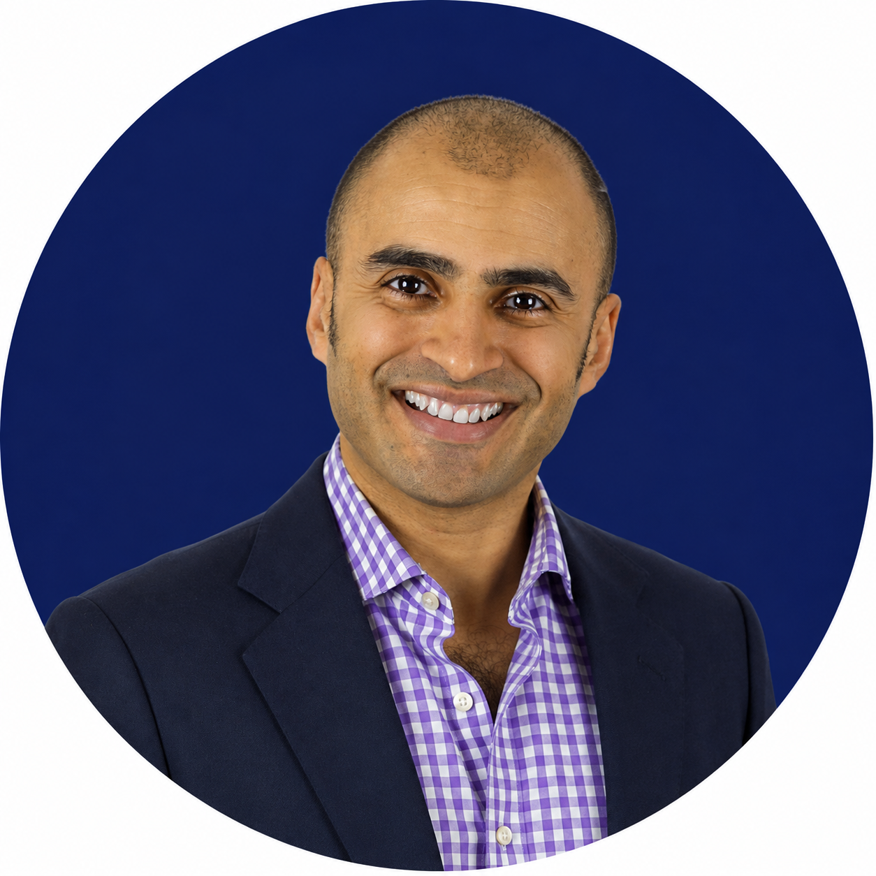 Smiling bald man in a navy blazer and purple checked shirt against a dark blue circular background